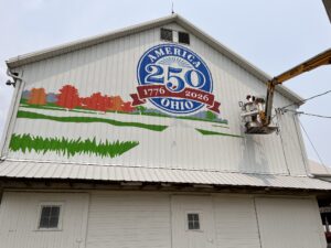 Photo, Scott Hagan, The Barn Artist, painting a barn mural for America 250.